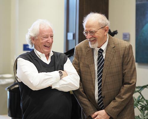 Two alumni members laughing during Richard Hayes event.